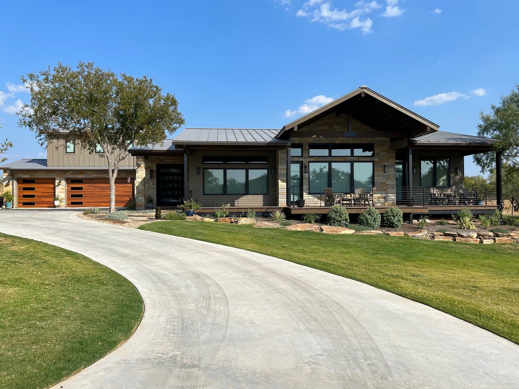 Rustic home with timber gables, stone and wood siding and a long curving driveway